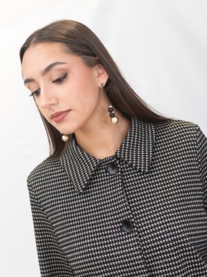 “Mujer con chaqueta de pata de gallo Surkana combinada con pantalón a juego, look elegante disponible en La Acicalá.”