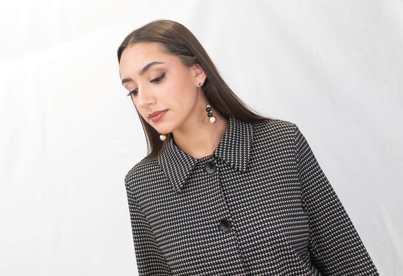 “Mujer con chaqueta de pata de gallo Surkana combinada con pantalón a juego, look elegante disponible en La Acicalá.”